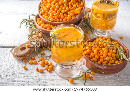 Hot autumn organic drink. Healthy diet beverage, immunity buster food. Sea buckthorn tea with orange and honey in a glass cups. White background copy space