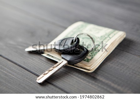 house keys and money. buying a house. on a gray wooden table