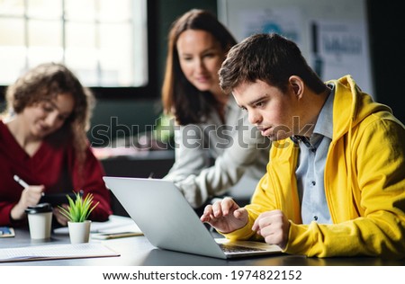 Down-syndrome man attending education class in community center, inclusivity of disabled person. Royalty-Free Stock Photo #1974822152
