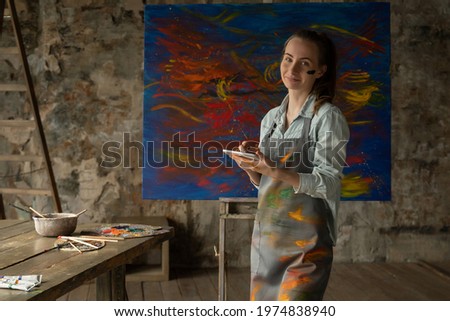 A talented artist using a tablet on the background of a painted picture