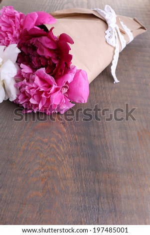 Bouquet of beautiful peonies on wooden background