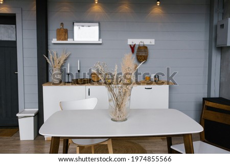Bouquet of dried flowers in a glass vase on the background of Scandinavian cuisine