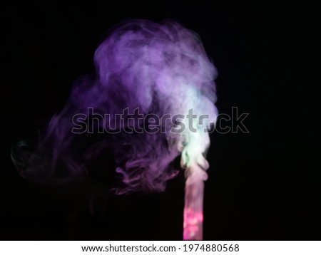 Abstract color series. Composition of colorful smoke in motion. 
Fusion of purple, pink and white mist isolated on a dark background to inspire creativity.