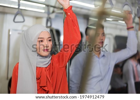 Asian muslim woman wear hijab head scarf in the metro or train subway, public transport Royalty-Free Stock Photo #1974912479