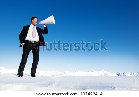 Businessman shouting on snow covered mountain.