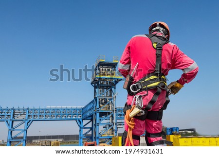 Engineer wearing equipment protection safety harness and Check readiness equipment before for rope access on pipe line station on rack background with copy space for text Royalty-Free Stock Photo #1974931631