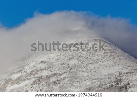 The snowy peaks of the Sestra mountain in the Lazovsky district of the Primorsky Territory. Snow storm on the top of the mountain