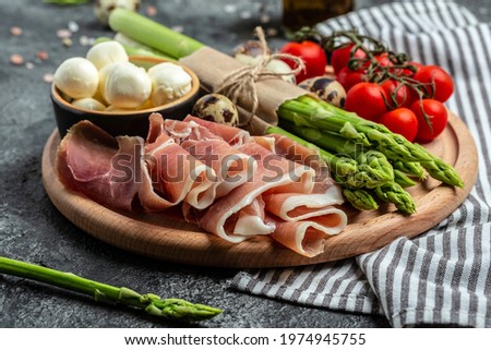 Fresh prosciutto with mozzarella cheese and cherry tomatoes. Ingredients for tart, pizza or pie,