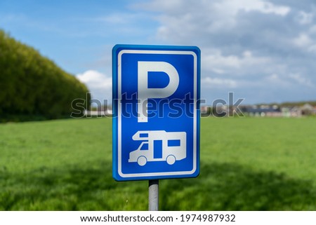 A selective focus view of a blue parking lot sign for camper vans and caravans