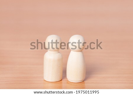 wooden doll couple stands on wood table with copy space.