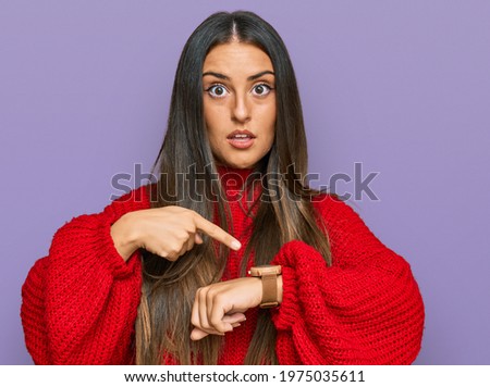 Beautiful hispanic woman wearing casual clothes in hurry pointing to watch time, impatience, upset and angry for deadline delay 