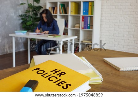 HR policies guide book on desk near employee. Royalty-Free Stock Photo #1975048859