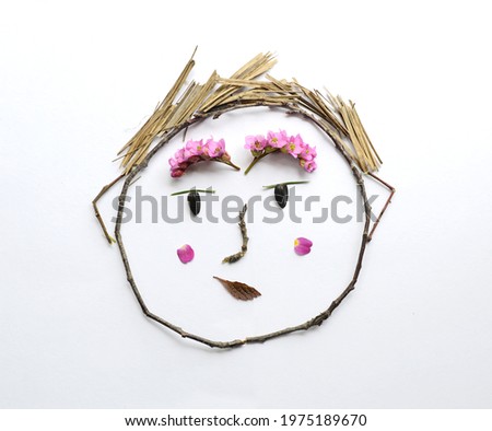 Portrait of a boy from flowers and branches, natural creativity on a white background, funny character.