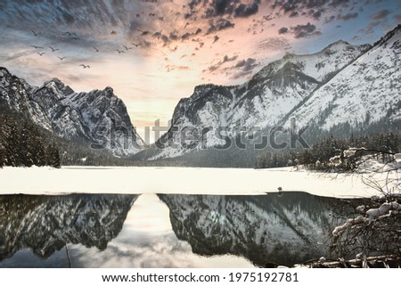 Reflection of Lake Landro, in Val Pusteria in Bolzano, one evening during the winter season Royalty-Free Stock Photo #1975192781