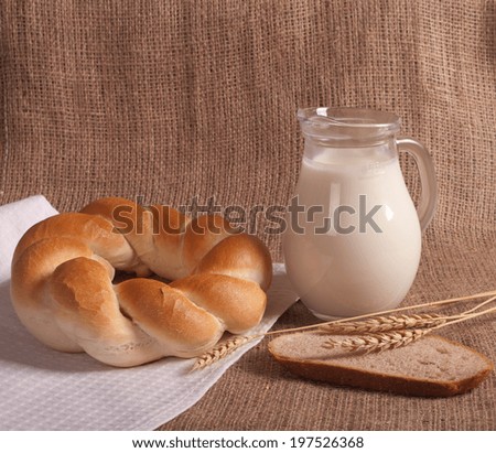 jug with milk and bread on burlap background