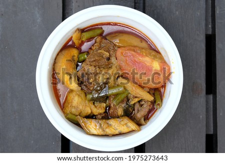 Flatlay picture of beef dalca served during Eid Mubarak. Dalca is a stewed vegetable curry with lentils add meat that is famously served with briyani and tomato rice.