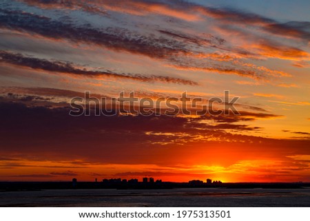 Sunset on the river. Colorful landscape with river and blue sky with multicolored clouds. River sunset panorama.