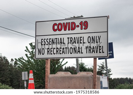 View of sign on the road Essential Travel Only, No recreational Travel due to Covid-19 in Vancouver area, Canada