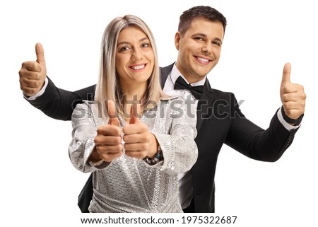Elegant young man and woman gesturing thumbs up isolated on white background