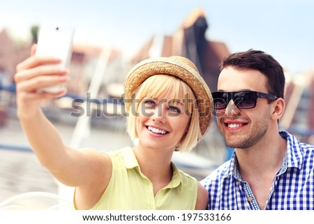 A picture of a happy couple taking pictures of themselves in Gdansk Marina