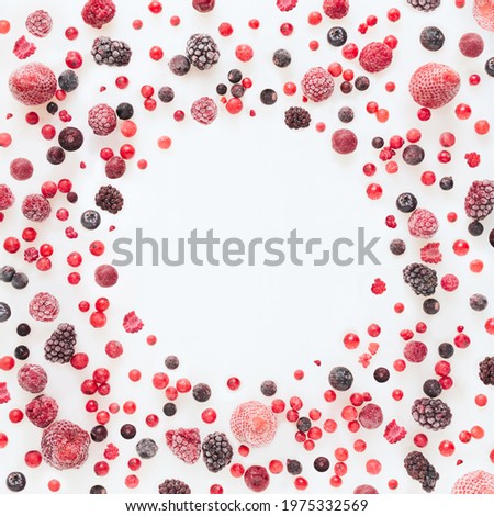 Abstract pattern with frozen strawberry, raspberry, currant, cherry, blueberry and blackberry fruits on isolated pastel white background with circular copy space. Food card concept. Minimal flat lay.