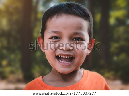 Portrait of happy smiling Asian child boy in nature, outdoors