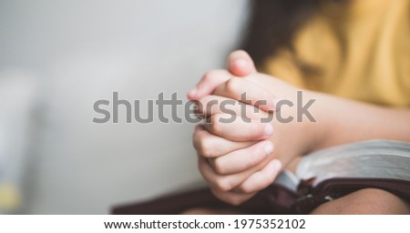 pray worship online at home.home church worship in sunday service.kid child girl hand praying and bible study.hope, faith, trust in GOD.Worship christian before bible study at home, close up hand pray Royalty-Free Stock Photo #1975352102