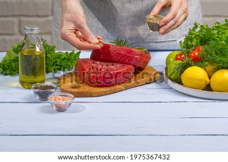 Cooking tuna steak. Fresh Atlantic bluefin tuna steak, with spices and ready for fry. The yellowfin tuna raw fresh medallion. close-up. Royalty-Free Stock Photo #1975367432