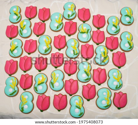 Gingerbread figurines lie on the table. 
Women's Day. spring flowers from gingerbread dough