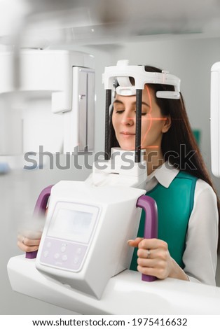 Young woman ready to computer 3d tomography of teeth and jaw in modern dental clinic