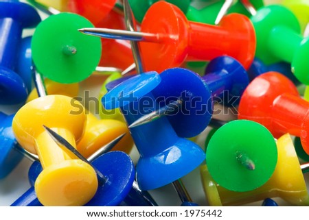Colored pins from above on a white background