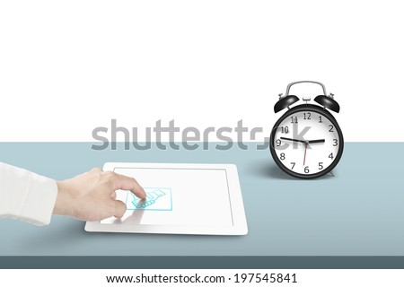 Touching hand shake icon on tablet with alarm clock