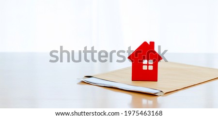 House on document envelope. complete the insurance policy, rental documents and loan document. concept guy buying new house
