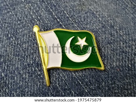 Pakistani flag badge on blue jeans background.