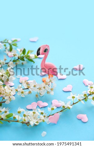 Flamingo toy, white flowers, pink hearts on blue background. symbol of gentle romantic dreams, spring summer relax concept. minimal creative style