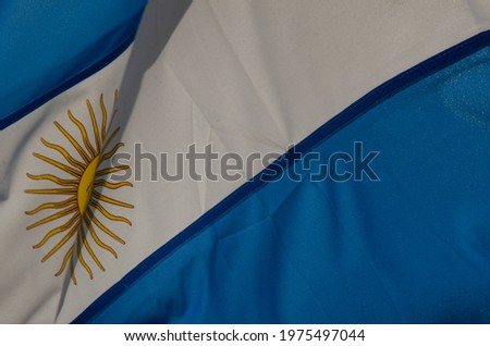 background and texture of fabric of the blue and white flag of the Argentine nation, with the characteristic yellow sun of this flag waving