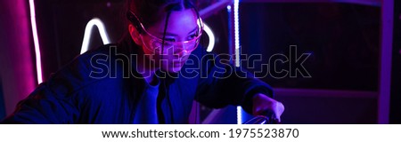 young asian woman in sunglasses near neon lighting, banner
