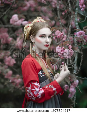 White-skinned girl in a beautiful hanbok  in a blooming spring garden