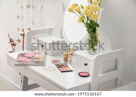 Table with mirror and decorative cosmetics in modern makeup room Royalty-Free Stock Photo #1975536167