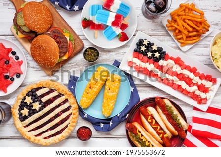 Fourth of July, patriotic, American themed food. Above view table scene on a white wood background.