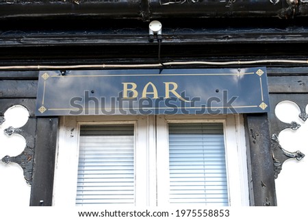 close up of sign for a  bar above a window outside a public house, restuarant in springtime