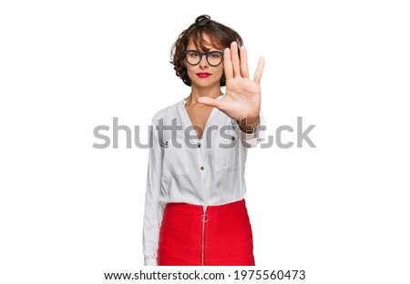 Young hispanic woman wearing business style and glasses doing stop sing with palm of the hand. warning expression with negative and serious gesture on the face. 