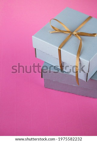 Two present boxes on the pink background