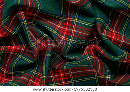 Texture of wrinkled, crumpled green and red tartan fabric close up. background for your mockup. traditional Scottish clothing Royalty-Free Stock Photo #1975582358