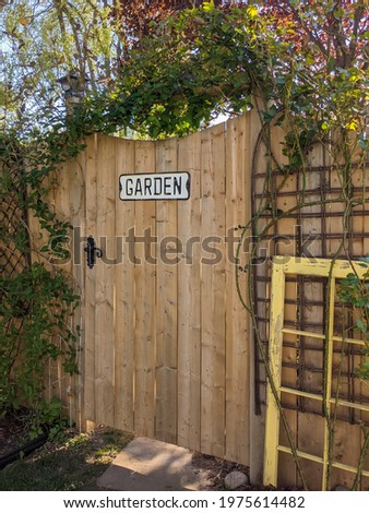 Garden sign on a wooden door that leads to back yard. Spring, summer hobby, house chores decoration, produce concept.