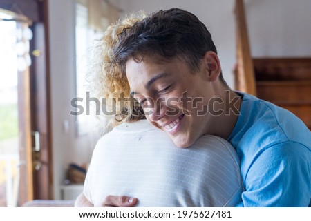 Loving teenager smiling enjoy moment strong cuddles adult mom after long separation, mother glad to see son multi generational family reunion, love and bonding concept Royalty-Free Stock Photo #1975627481