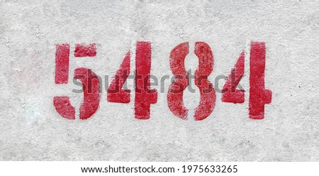 Red Number 5484 on the white wall. Spray paint.