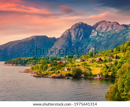 Captivating sunrise in Norway, Europe. Picturesque summer view of typical Norwegian village on the shore of fjord. Traveling concept background.
