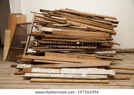 Large pile of hardwood floor being ripped out at an apartment during construction 