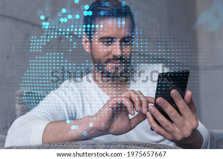 Double exposure of World map drawing hologram and a man searching information on phone in internet.